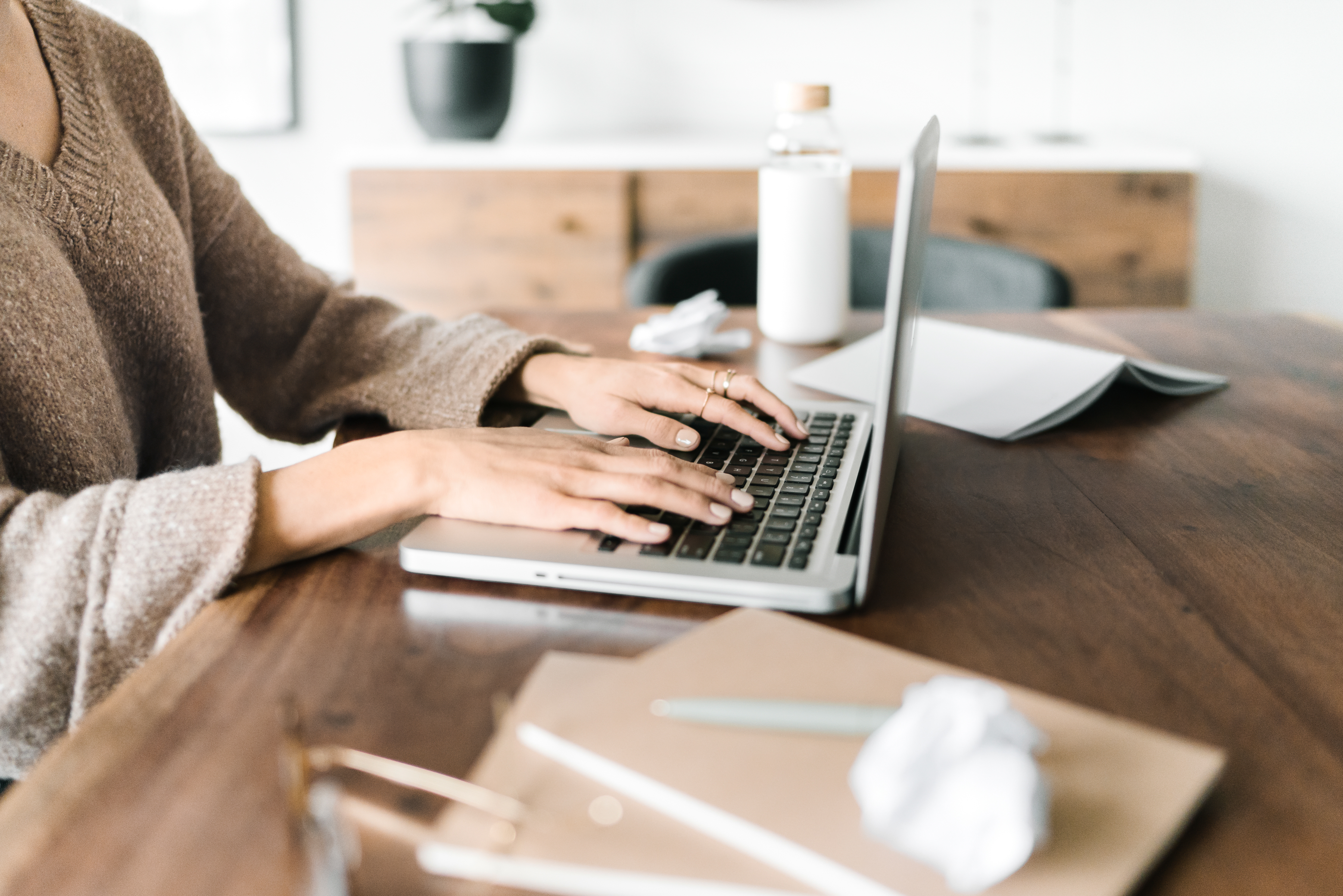 Woman typing on laptop at a desk representing using AI tools for online business tasks