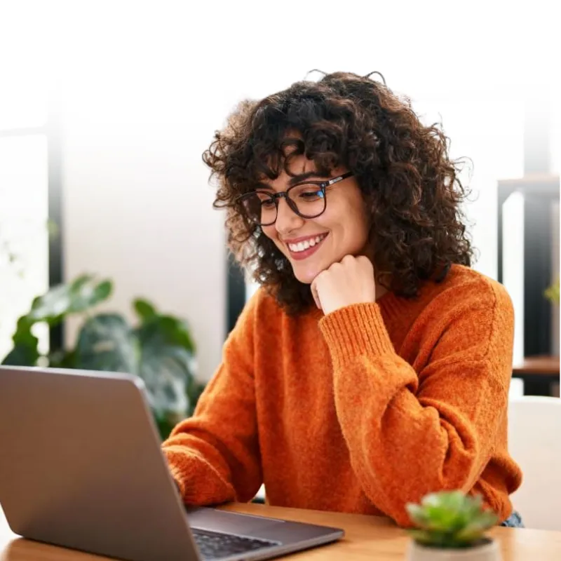 Woman smiling and looking at a laptop