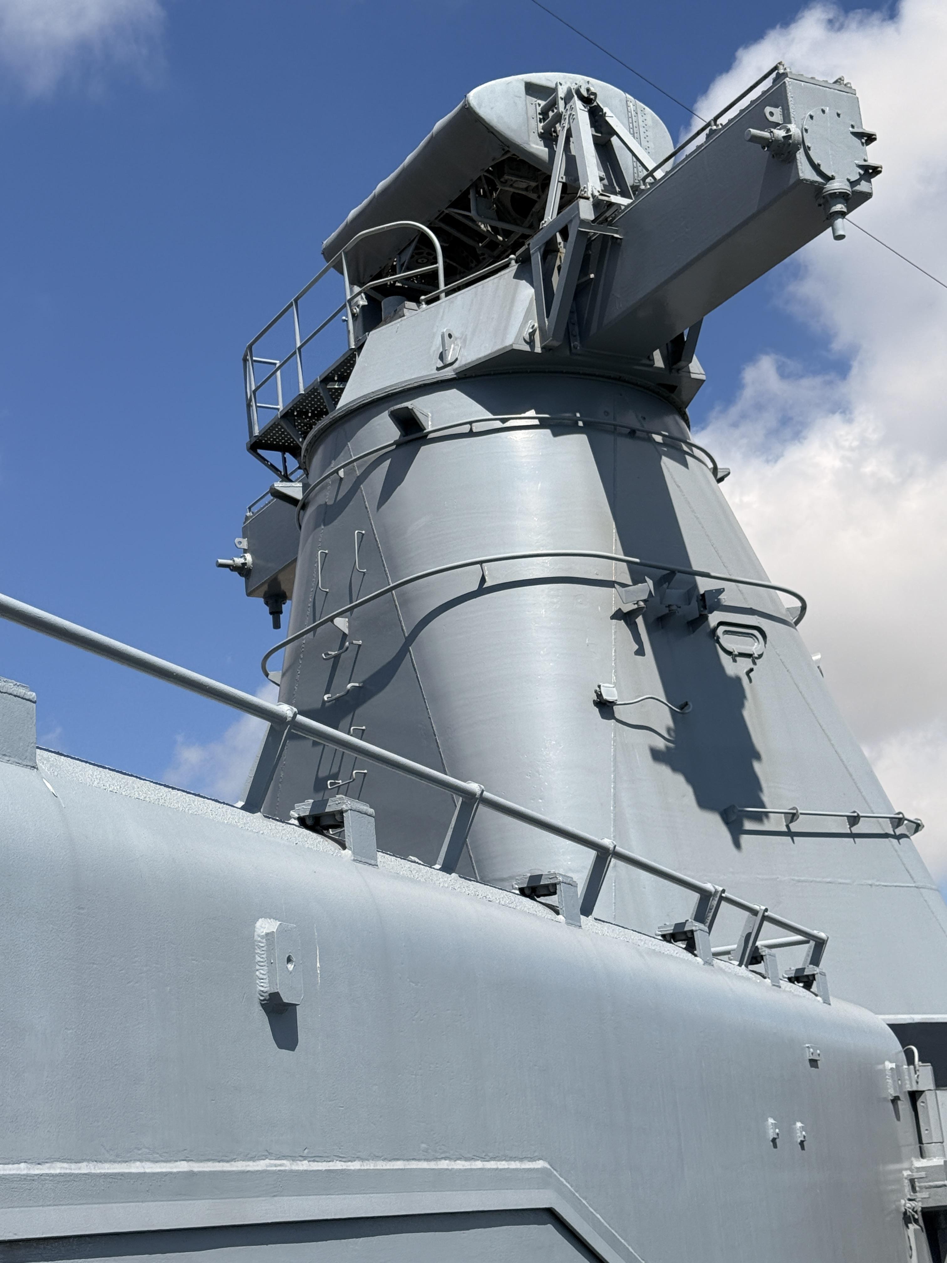 A dramatic upward shot of a gun turret/radar tower against a beautiful blue sky. Really striking composition