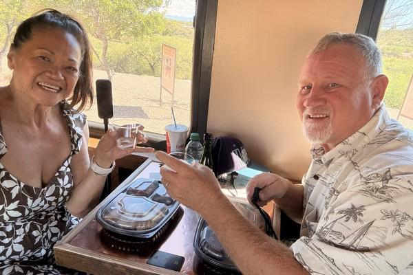 JoJann and Doug seated at a table inside the Verde Canyon Railroad car with refreshments.