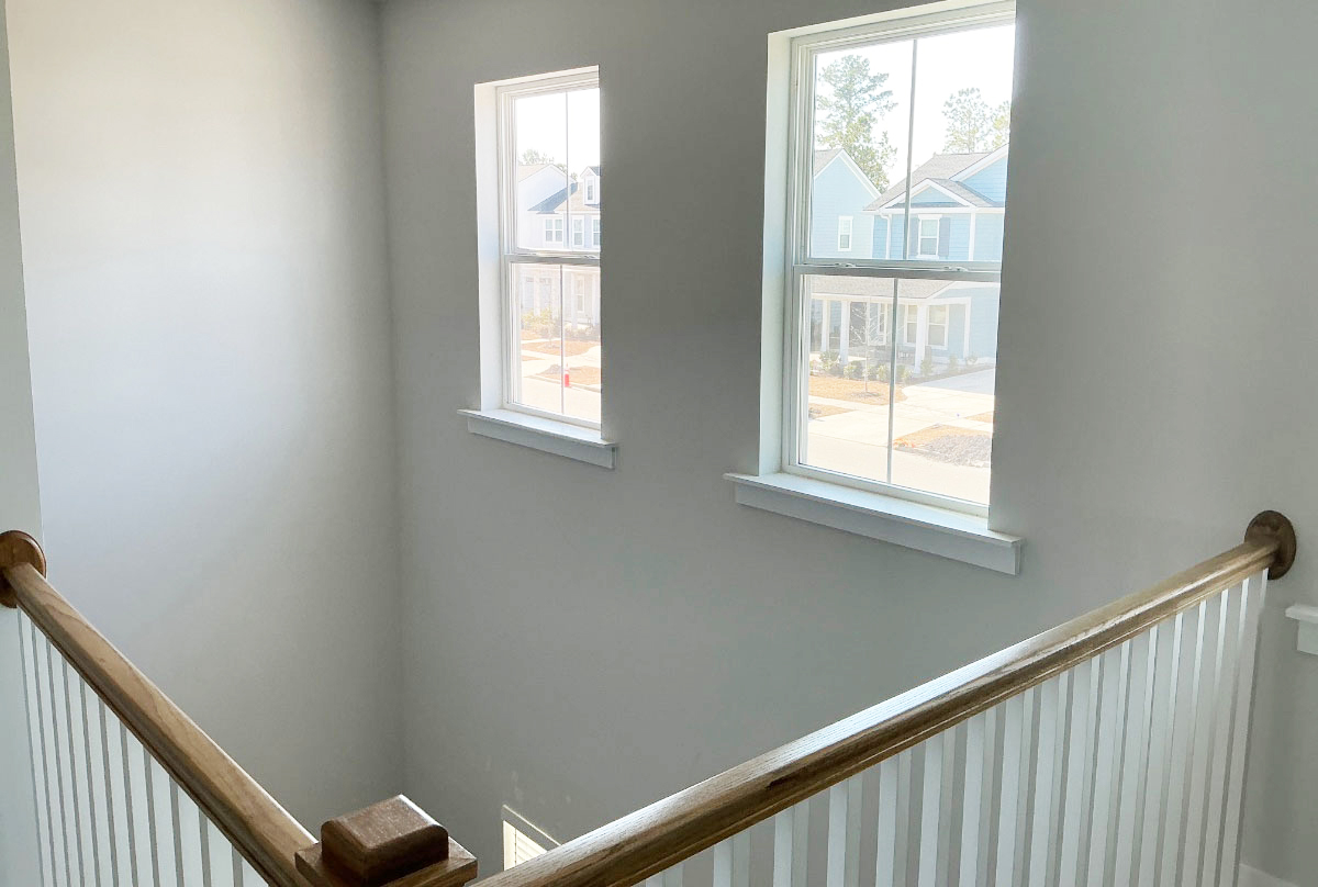 Freshly painted kitchen cabinets with white uppers and green lower cabinets in a residential kitchen