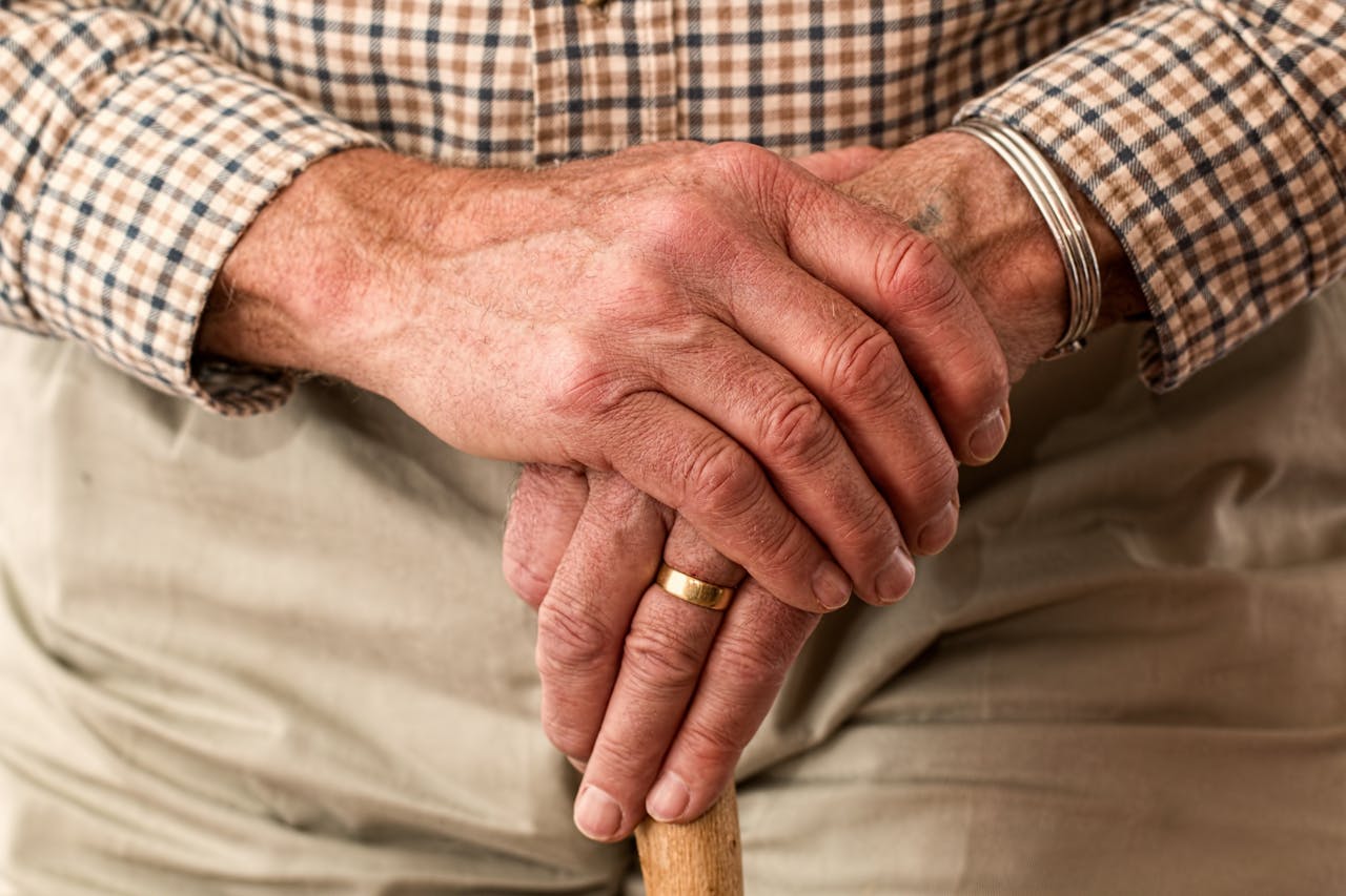 An older man gripping a cane