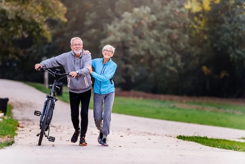 A couple walking together down a forrest road