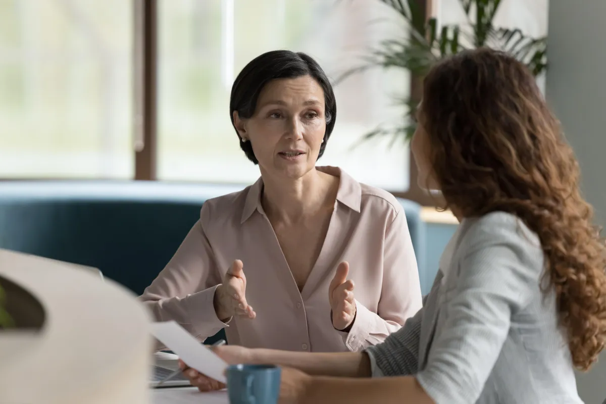 Two women talking in a professional setting.