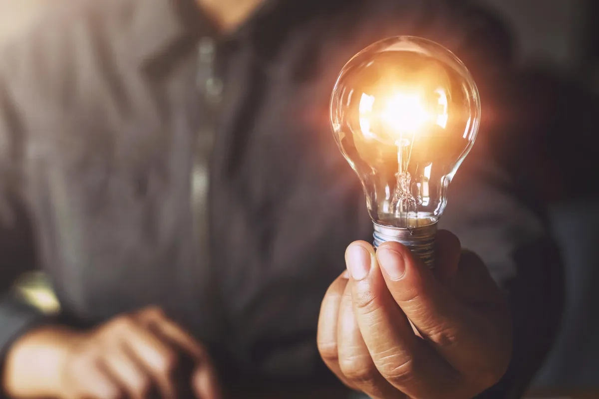Man holding up a lightbulb as a reference to an idea. 