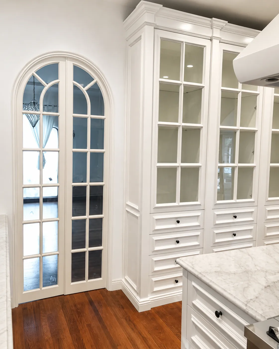 Custom white glass-front closet cabinetry in Santa Barbara