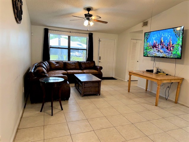 Living room area with tile flooring inside the home located at 755 SW Babbit Dr Port St Lucie Florida.