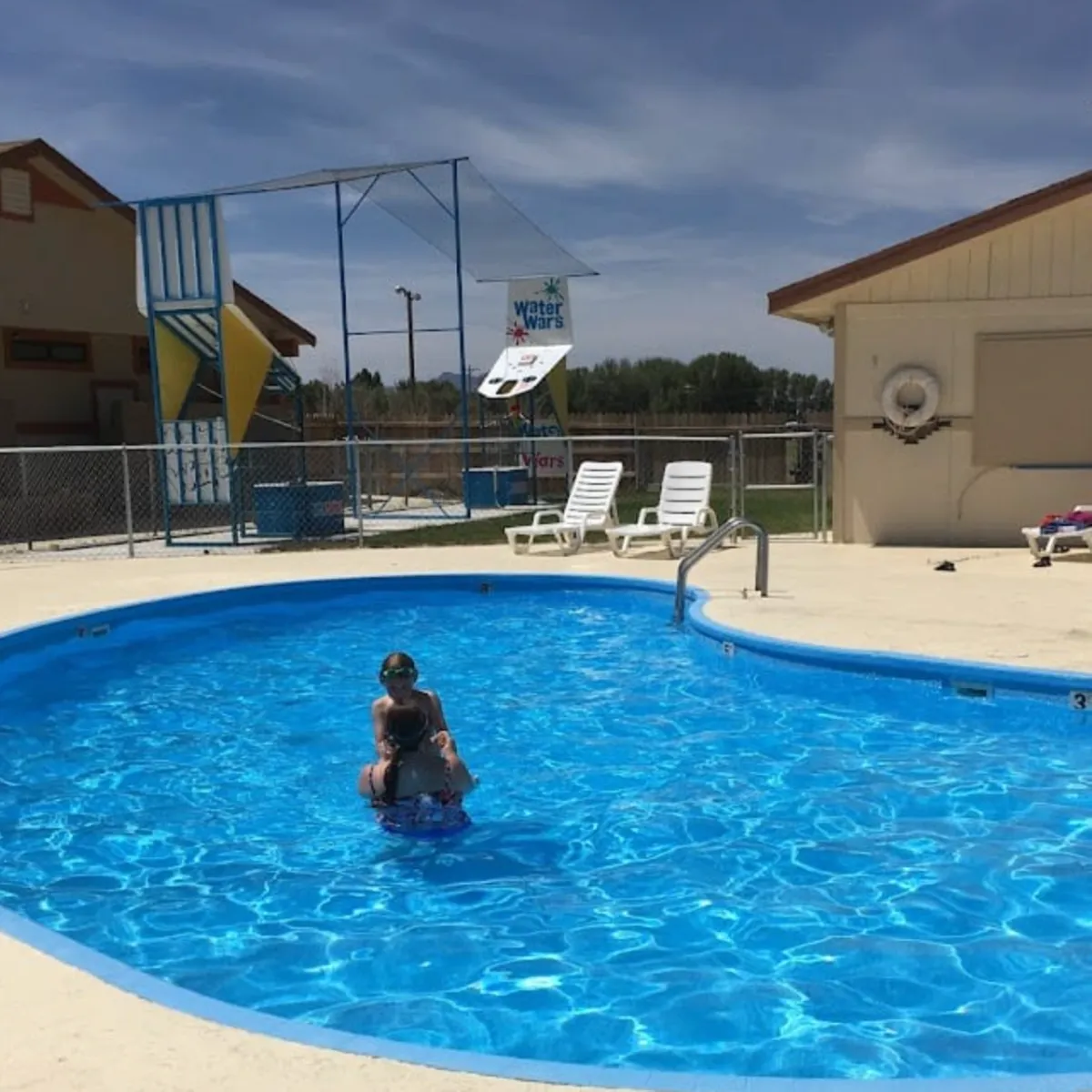 Families swimming in pool with mountain views