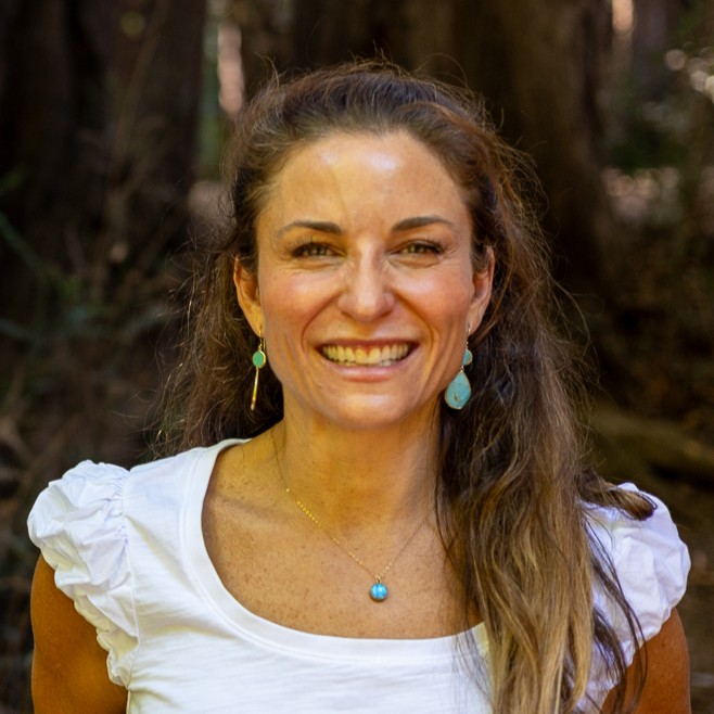 Founder portrait of Carrie Krane, mid-30s, approachable and professional, warm studio lighting, waist-up in a neutral workspace
