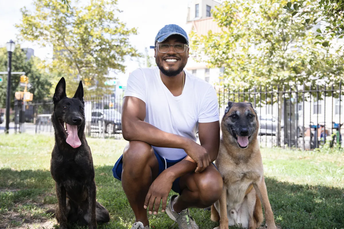 Twahlee, founder of Metro Dog Training, standing with disciplined composure in a high-contrast architectural setting in New York City