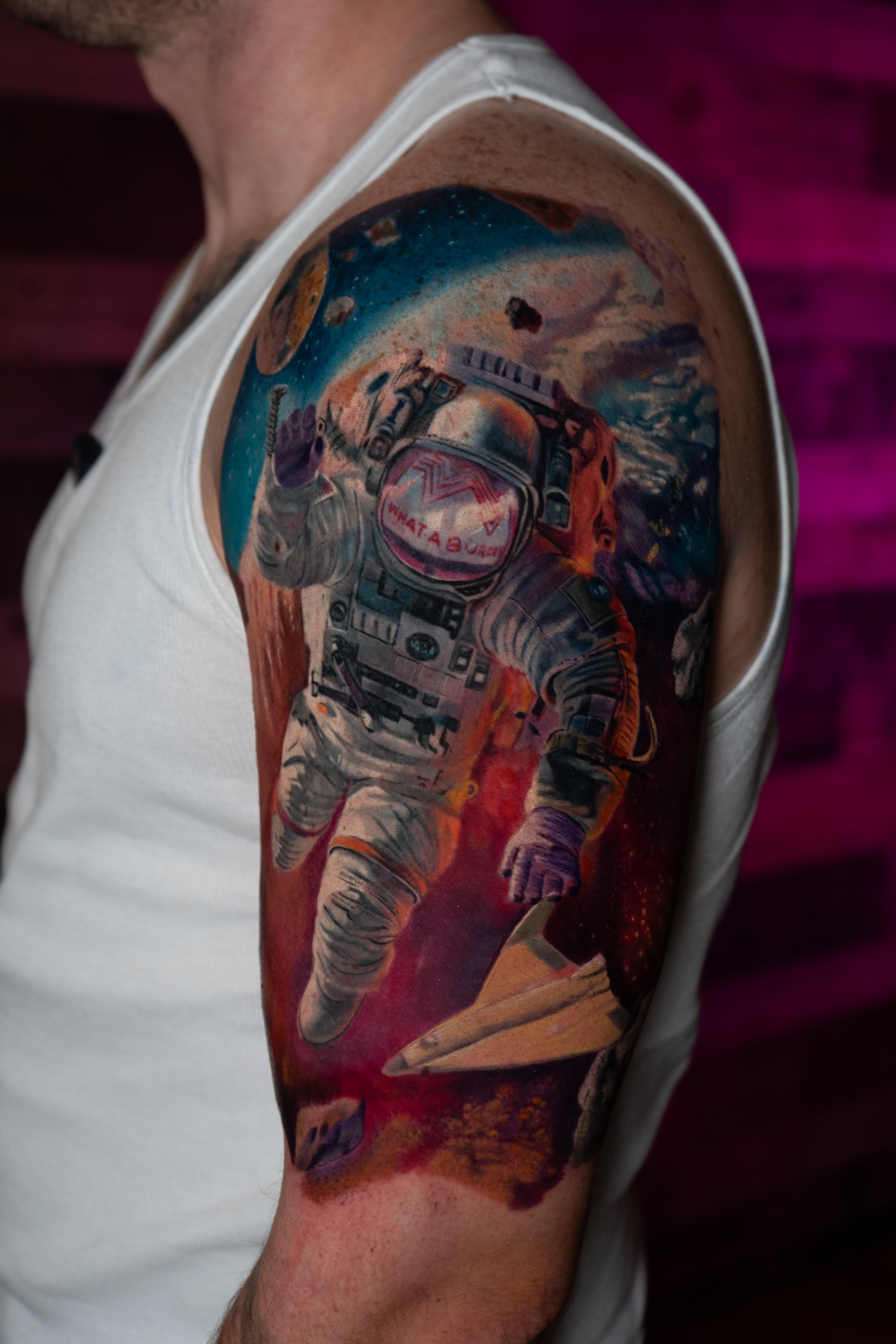 A tattoo artist is inking on a person's arm.