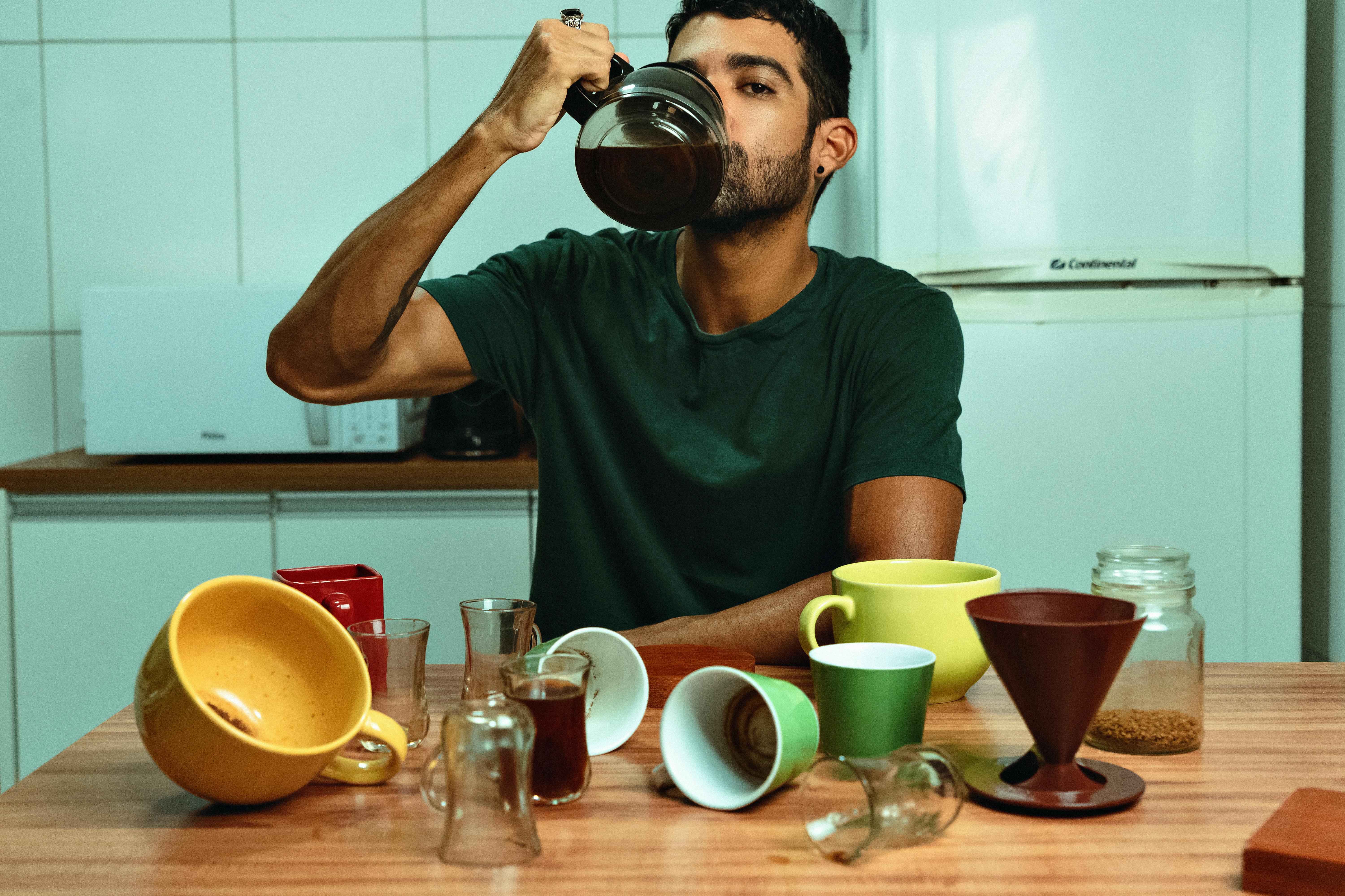 Man Drinking out of Coffee Pot