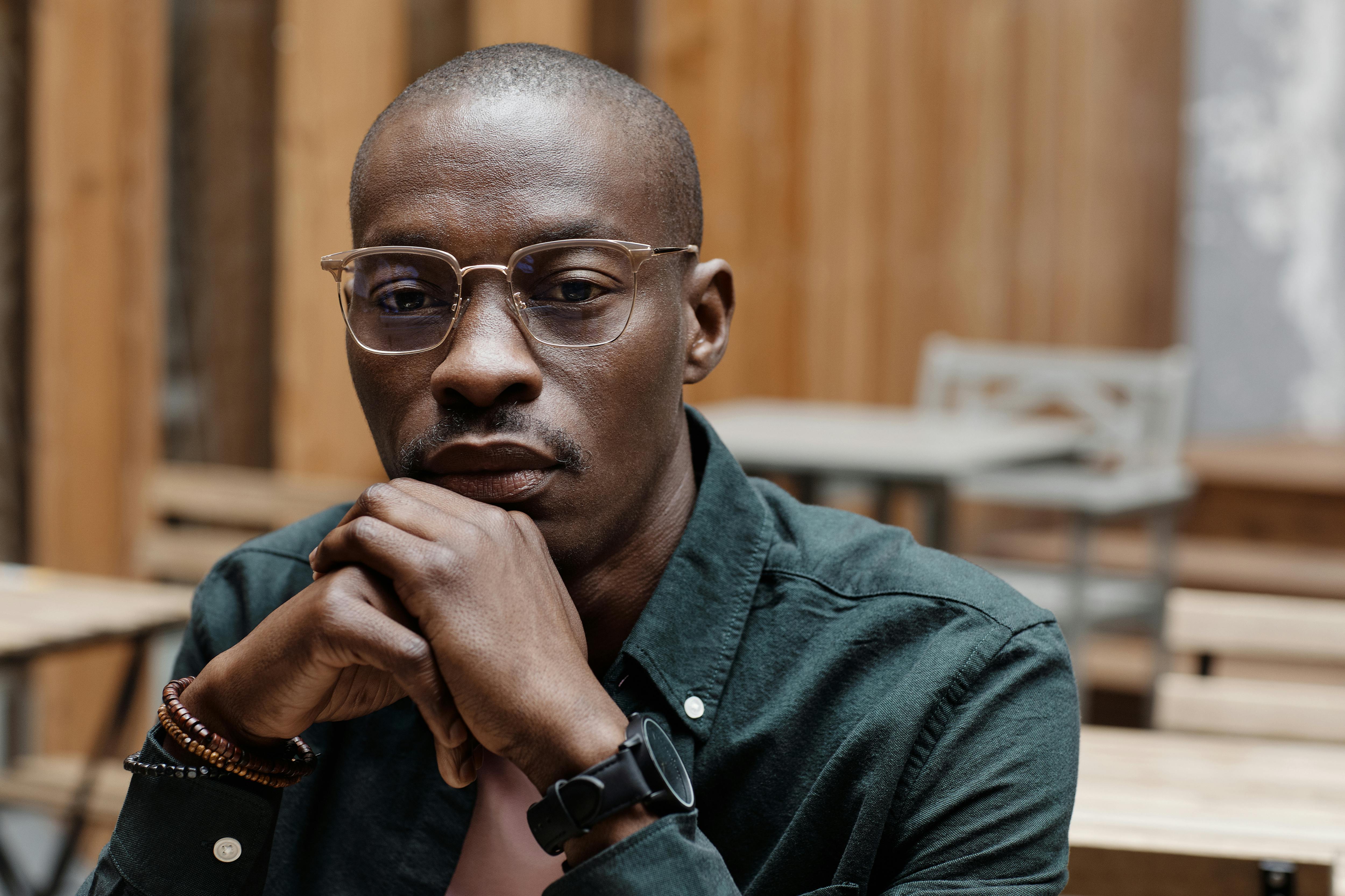 Close-up of a Man Wearing Eyeglasses and his Hand on his Chin