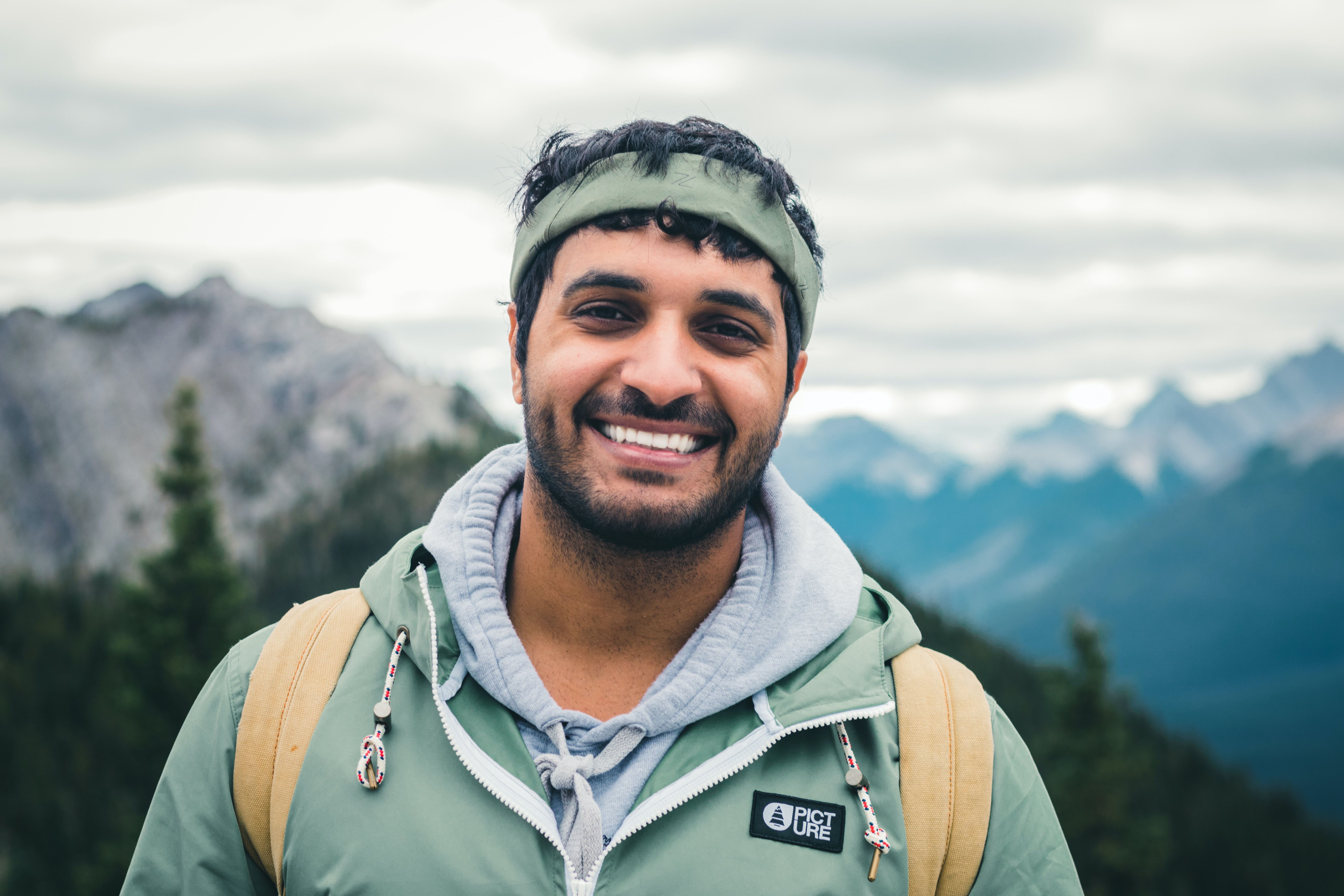 Happy young man with backpack enjoying the scenic views of the Canadian Rockies outdoors.