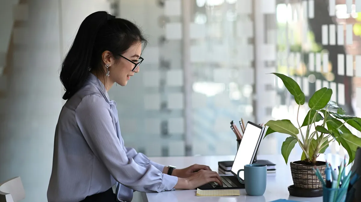 An asian woman working on her laptop