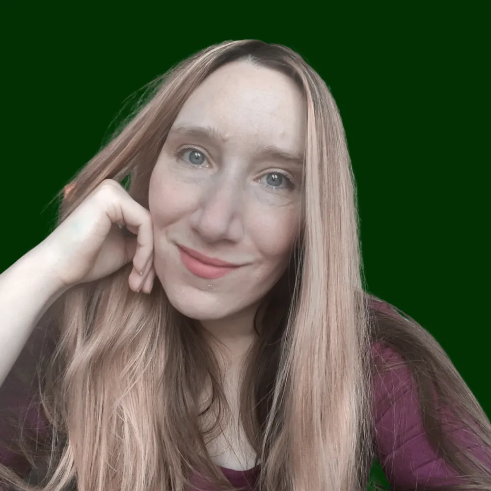 A relaxed portrait of Amelia Hastings. She is looking directly into the camera with her hand resting on her face.