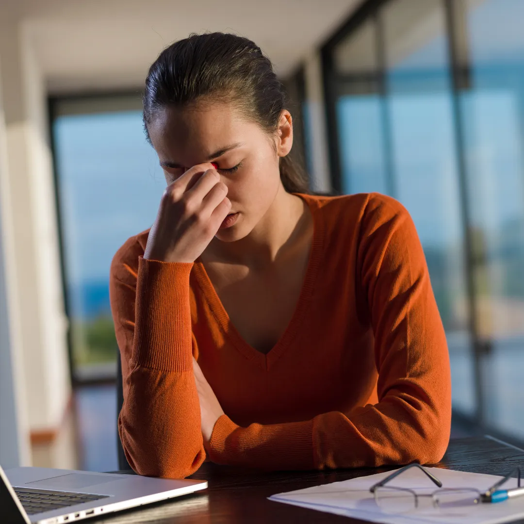 A young woman working from home looking frsutrated and stressd