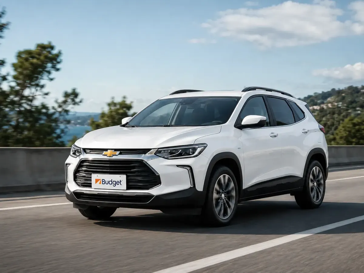 VehAuto Chevrolet blanco de Budget Ecuador circulando por carretera, ideal para alquiler de vehículos seguros y cómodos en viajes de turismo o negocios.ículo AVIS Ecuador circulando en carretera, flota moderna para turismo y renting
