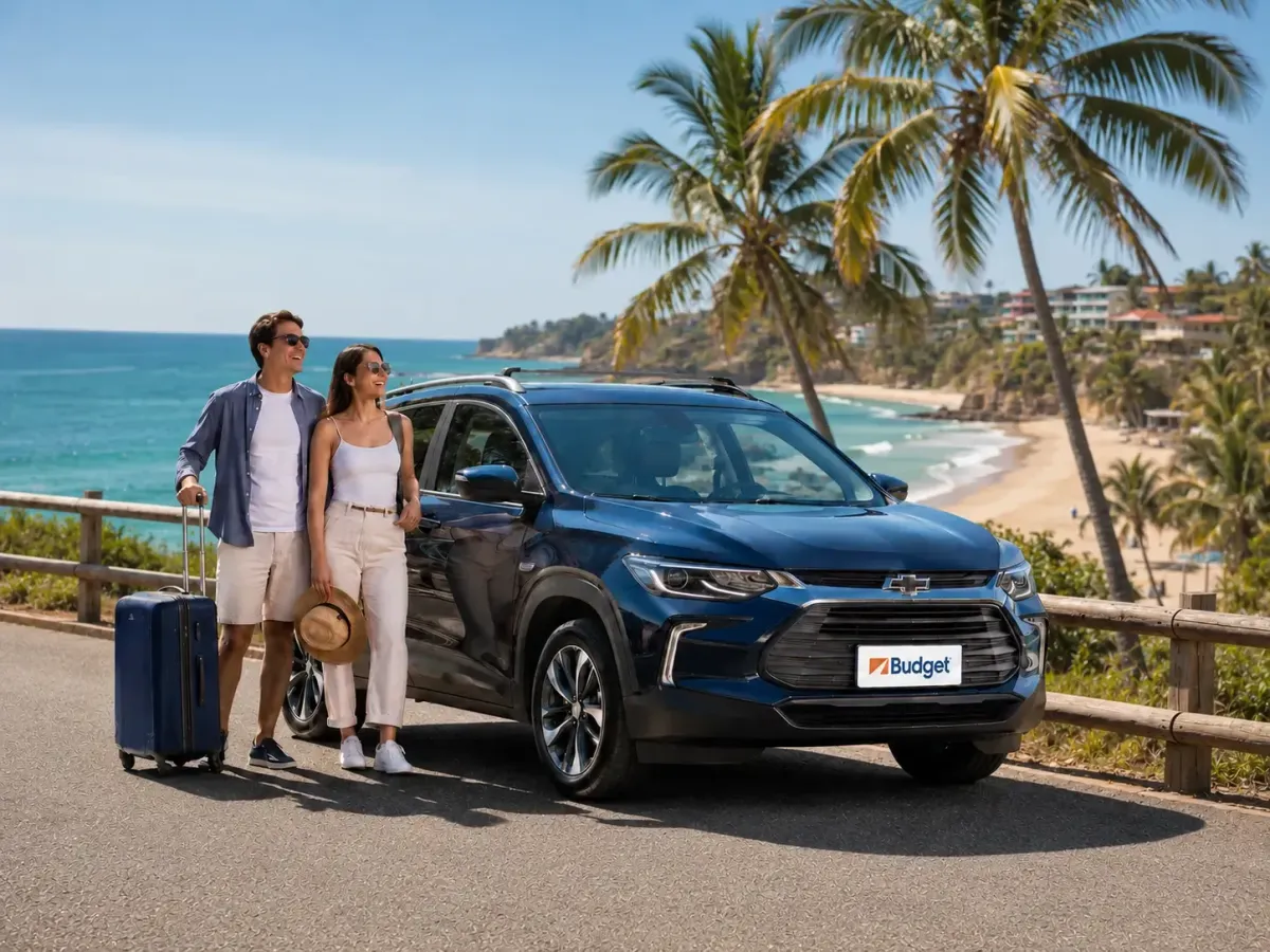 Pareja de turistas junto a un vehículo Chevrolet de Budget Ecuador frente a una playa, ideal para viajes y alquiler de autos turísticos en Ecuador.