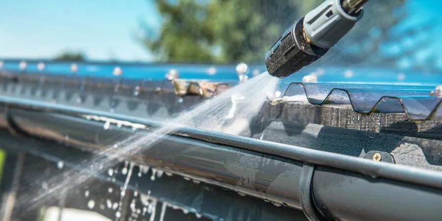 Using pressure wash to clean gutters on residential home in Albany Ga