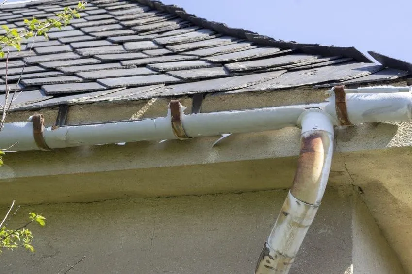 Damaged and rusted gutter with pieces missing