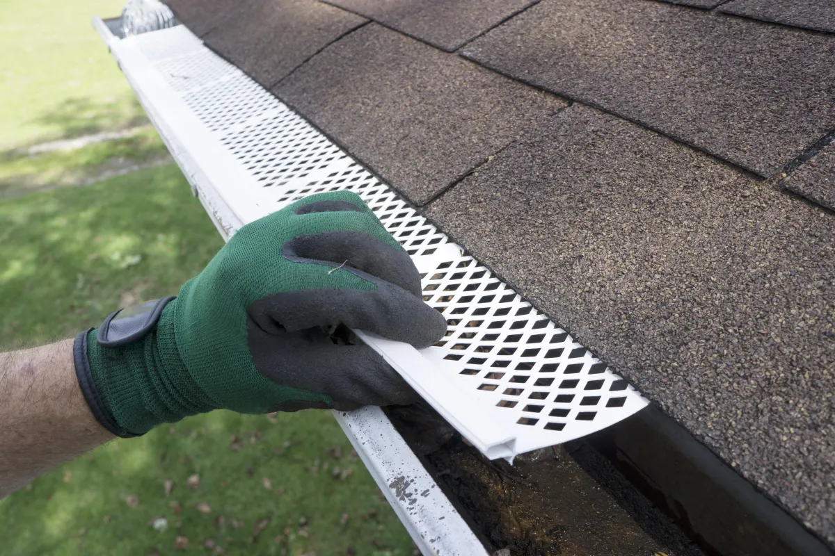 Gutter Repair Albany Ga contractor is adjusting plastic gutter guards on residential gutters in Albany GA