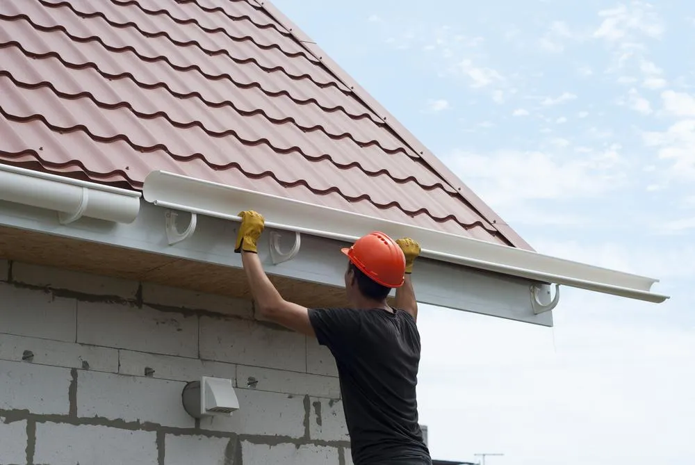 Team member installing a piece of a new gutter system on a home in Albany Ga 