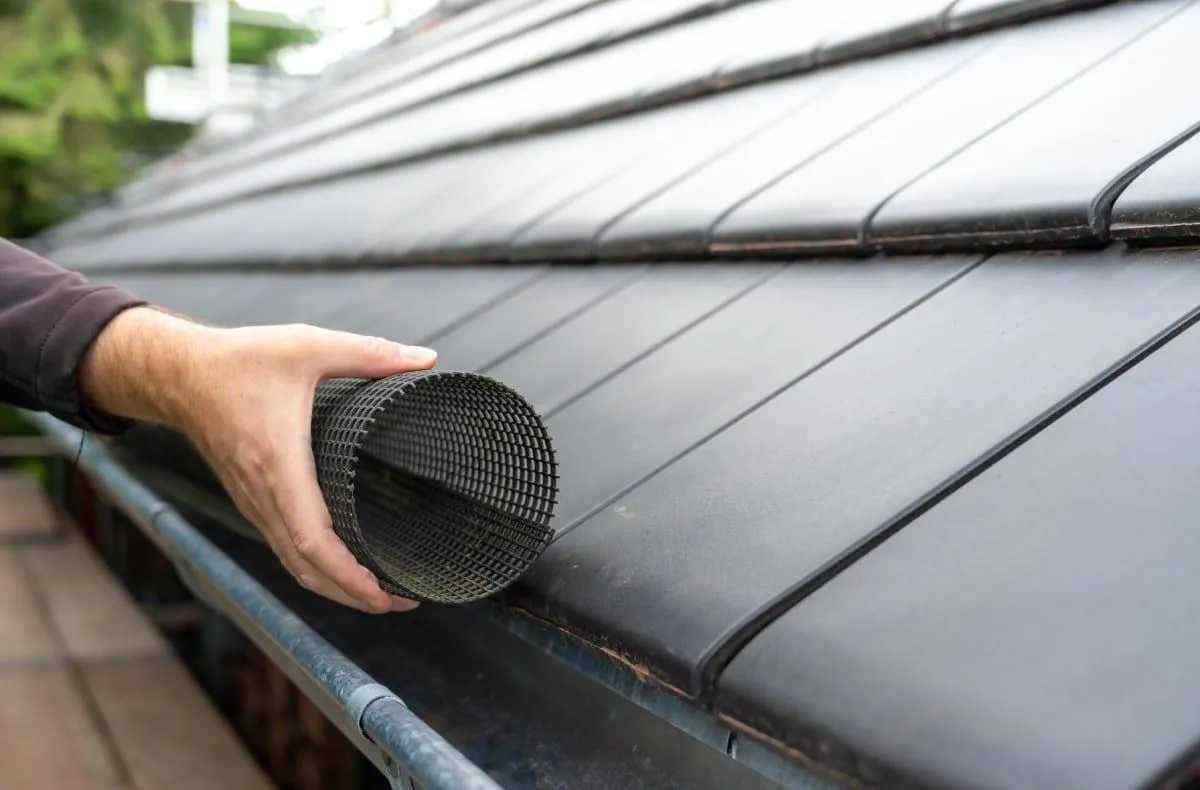 Contractor installing mesh gutter covers on home in Albany GA