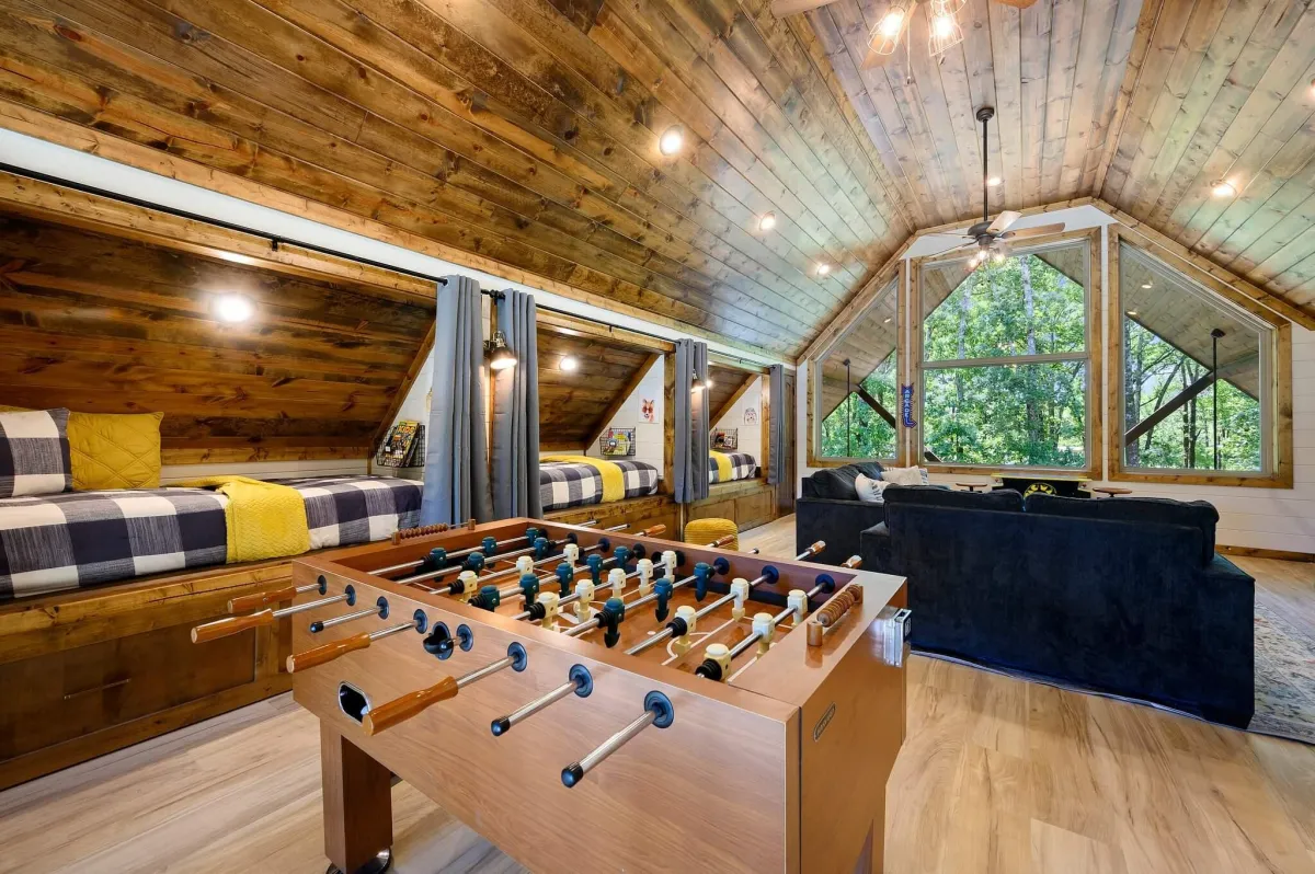 Charming loft bedroom with wooden ceilings, cozy beds, and rustic decor.