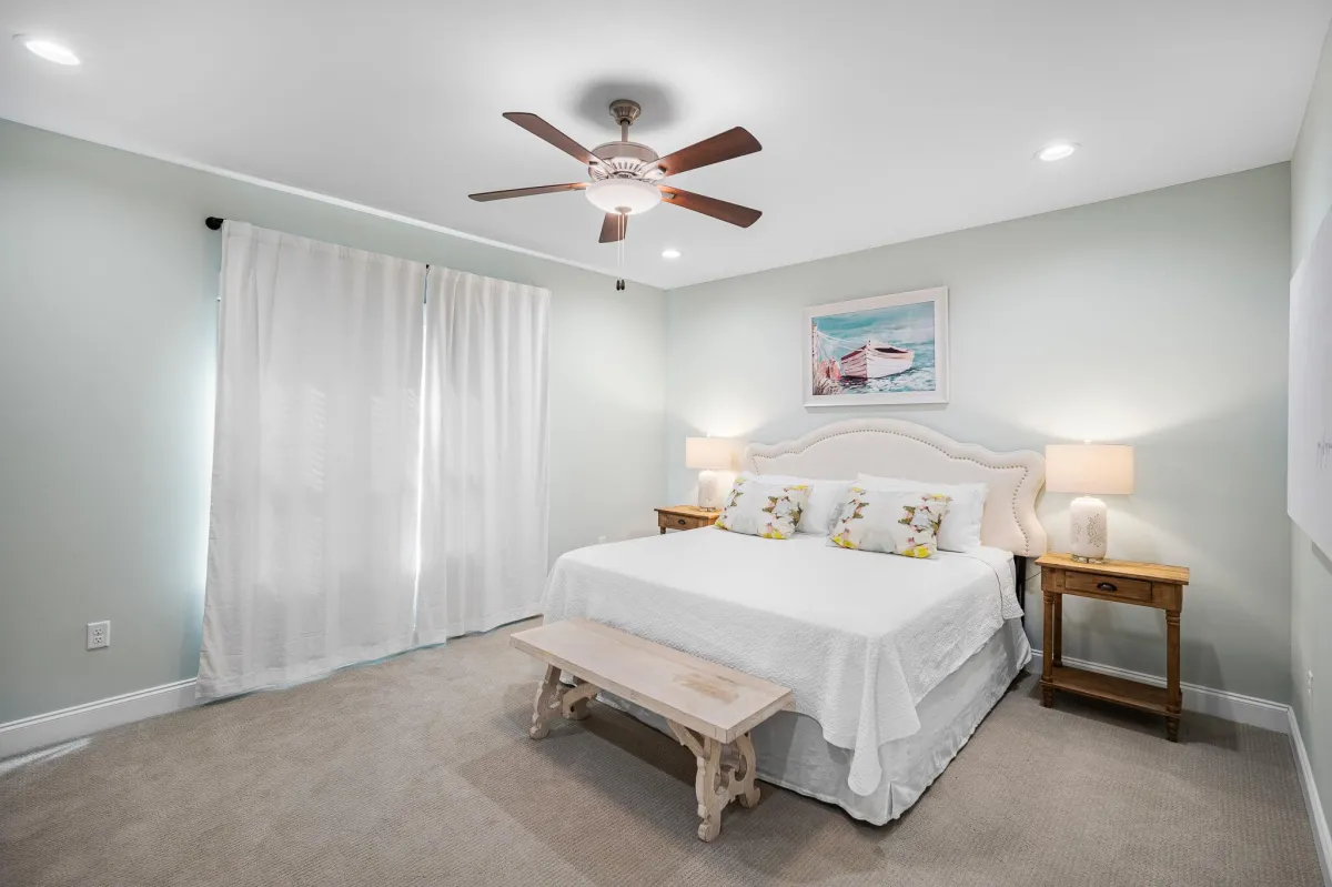 Inviting bedroom with large windows, plush bedding, and peaceful forest views.