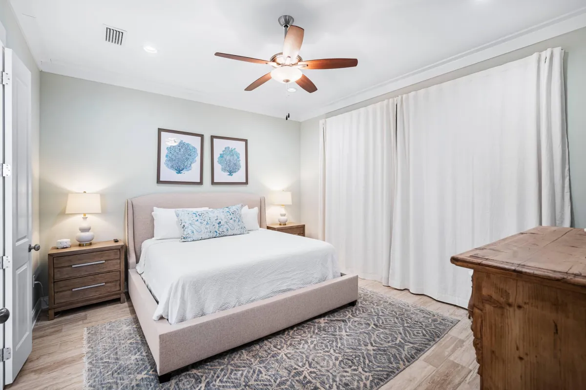 Inviting bedroom with large windows, plush bedding, and peaceful forest views.