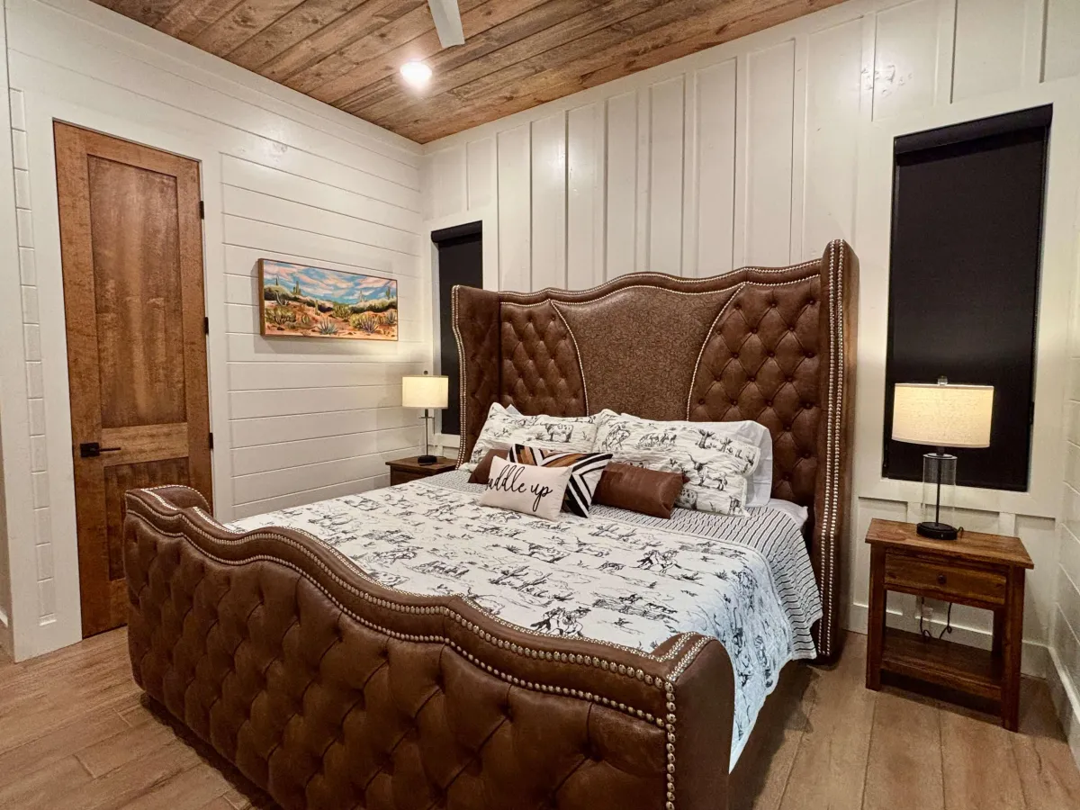Inviting bedroom with large windows, plush bedding, and peaceful forest views.