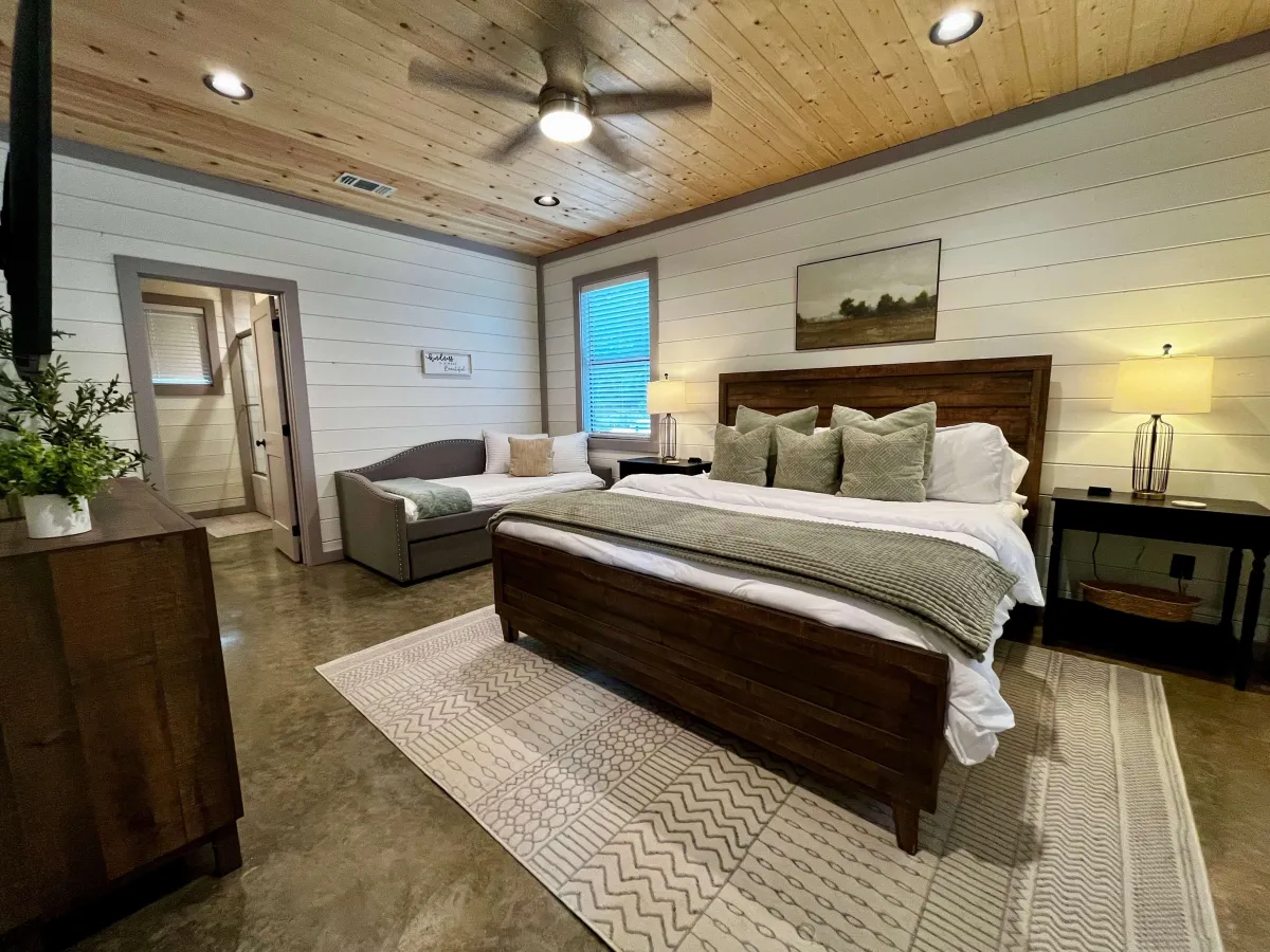 Rustic bedroom with wood accents, modern decor, and ample natural light.
