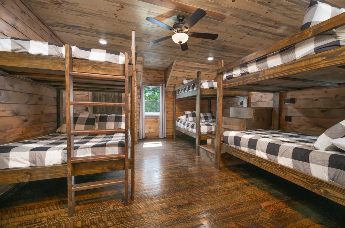 Rustic bedroom with bunk beds, wood ceiling, modern accents, and serene vibes.