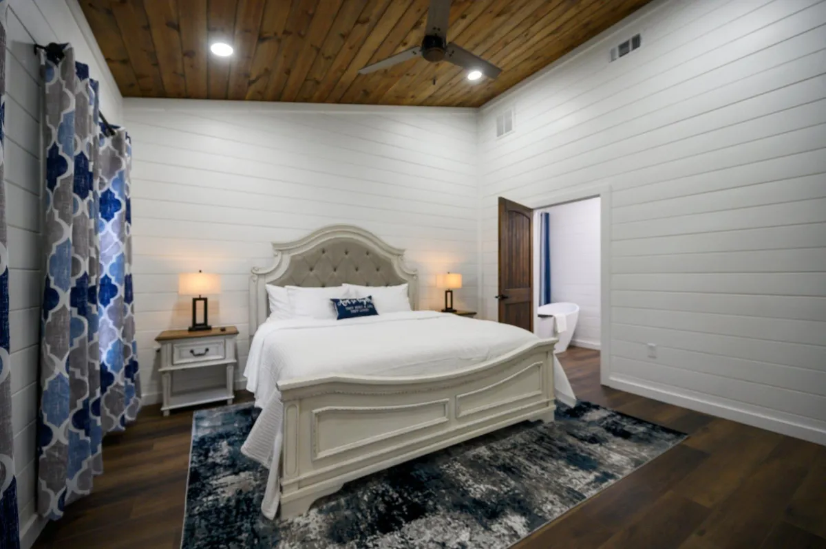 Inviting bedroom with large windows, plush bedding, and peaceful forest views.