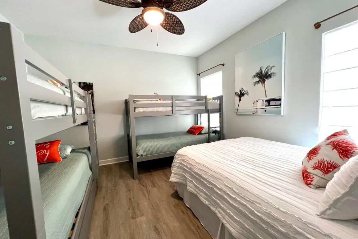 Charming loft bedroom with wooden ceilings, cozy beds, and rustic decor.