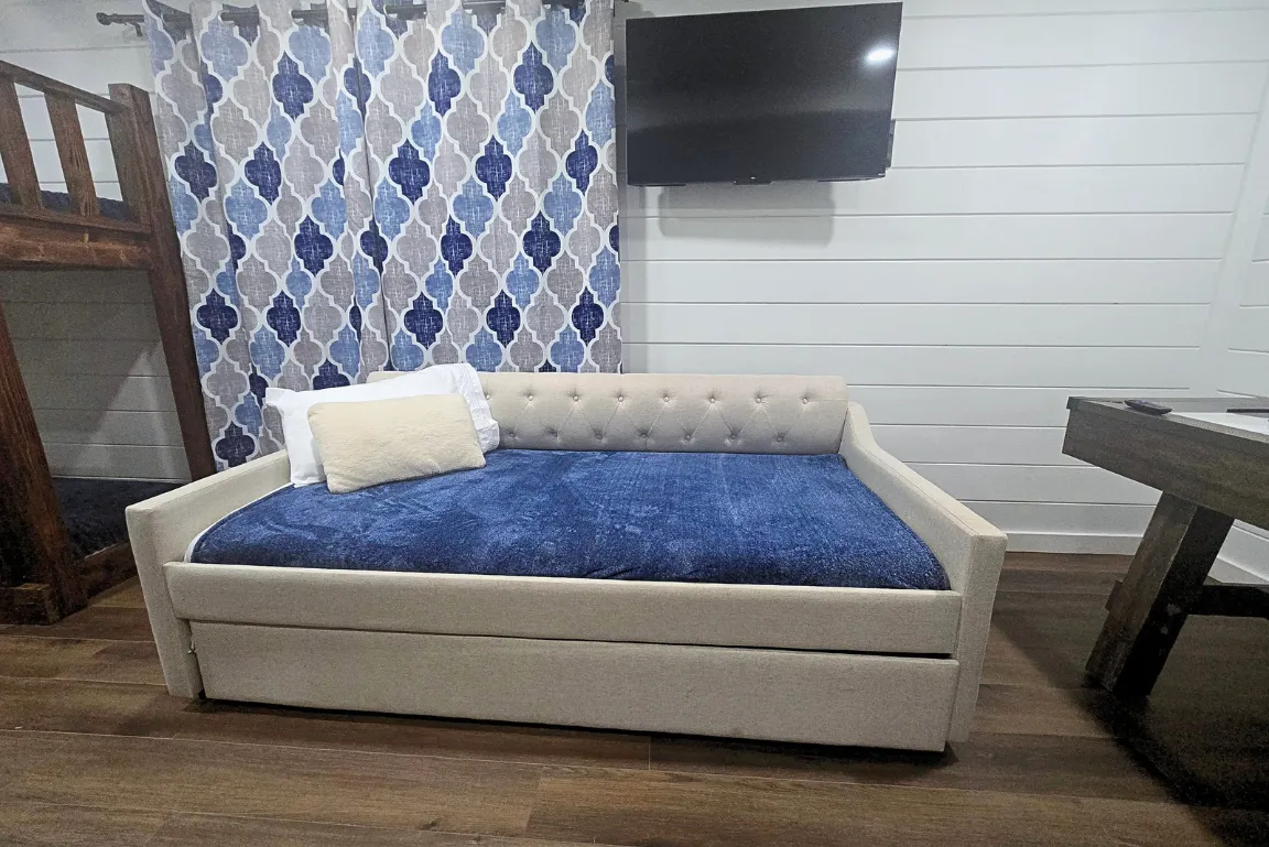 Inviting bedroom with large windows, plush bedding, and peaceful forest views.