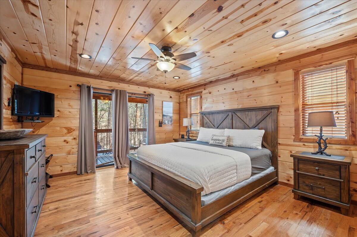 Inviting bedroom with large windows, plush bedding, and peaceful forest views.