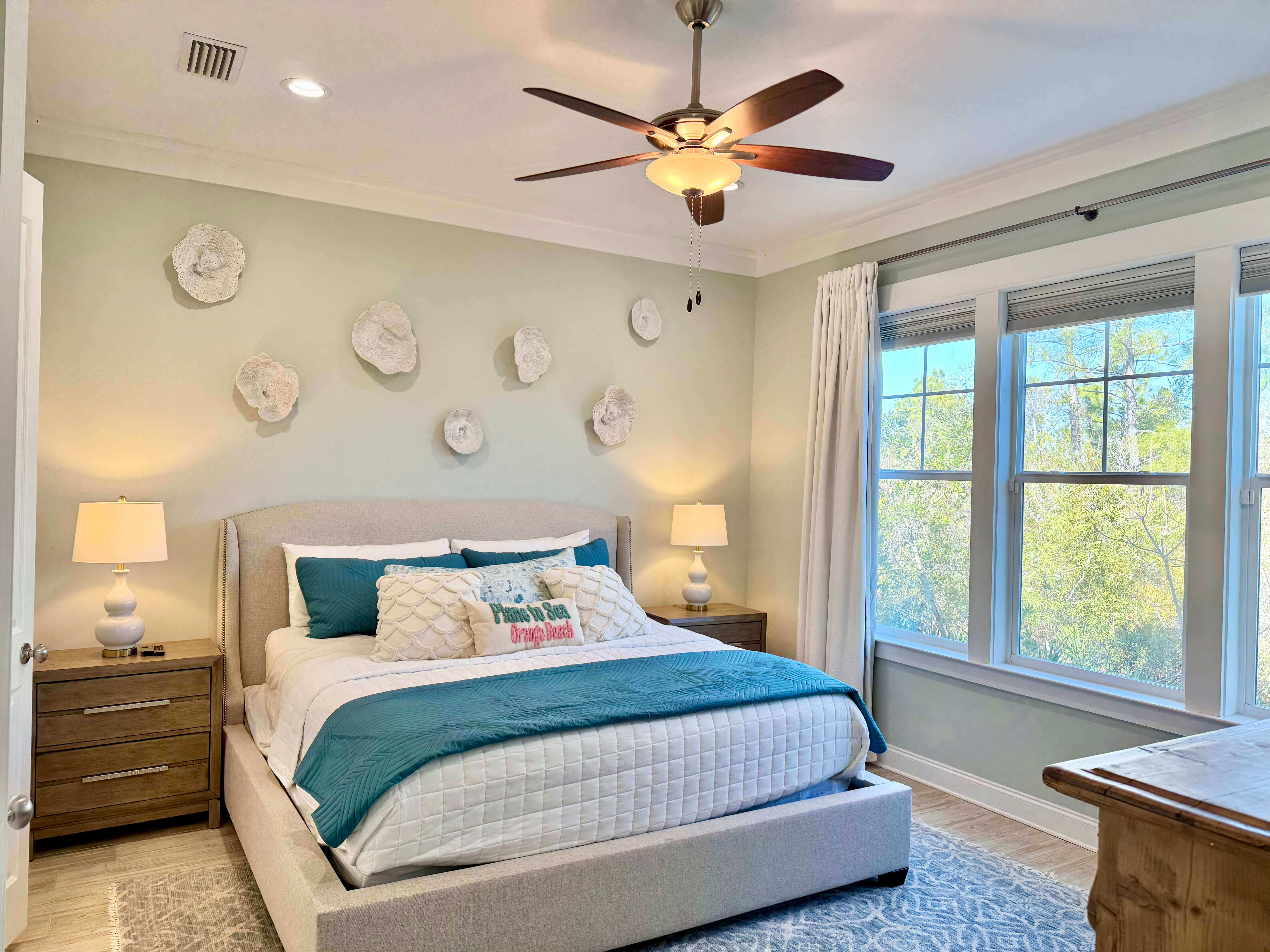 Inviting bedroom with large windows, plush bedding, and peaceful forest views.