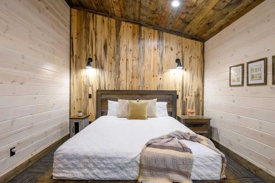 Rustic bedroom with bunk beds, wood ceiling, modern accents, and serene vibes.
