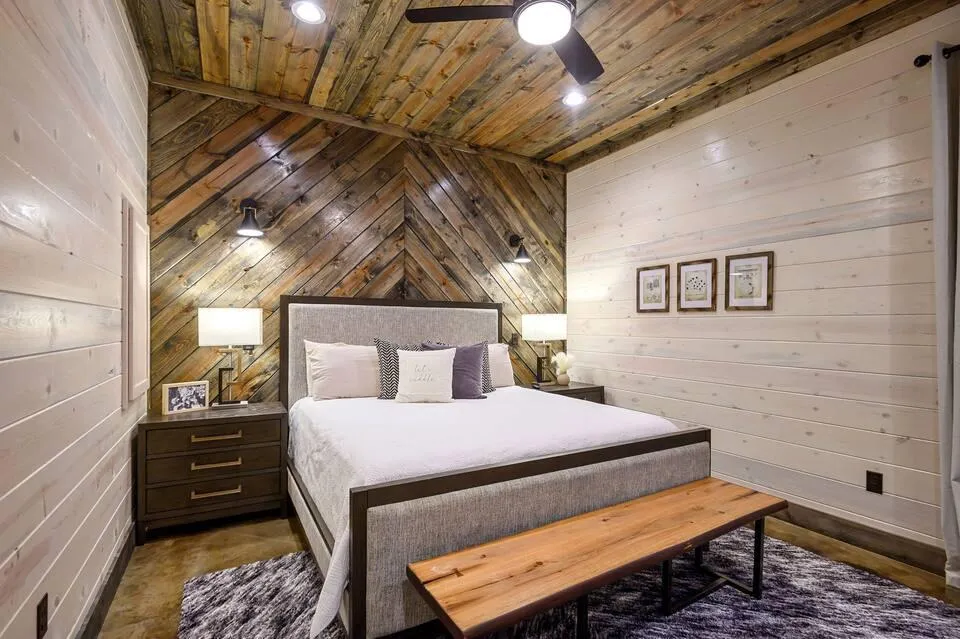 Inviting bedroom with large windows, plush bedding, and peaceful forest views.