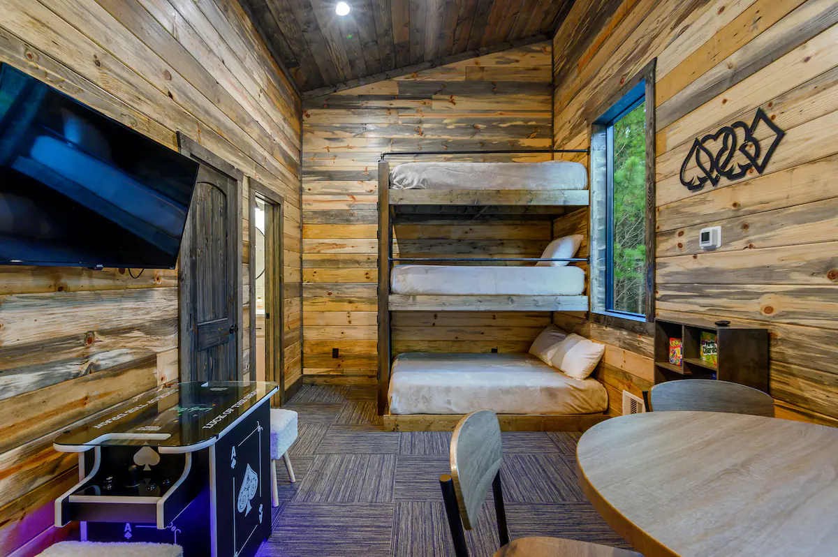 Charming loft bedroom with wooden ceilings, cozy beds, and rustic decor.