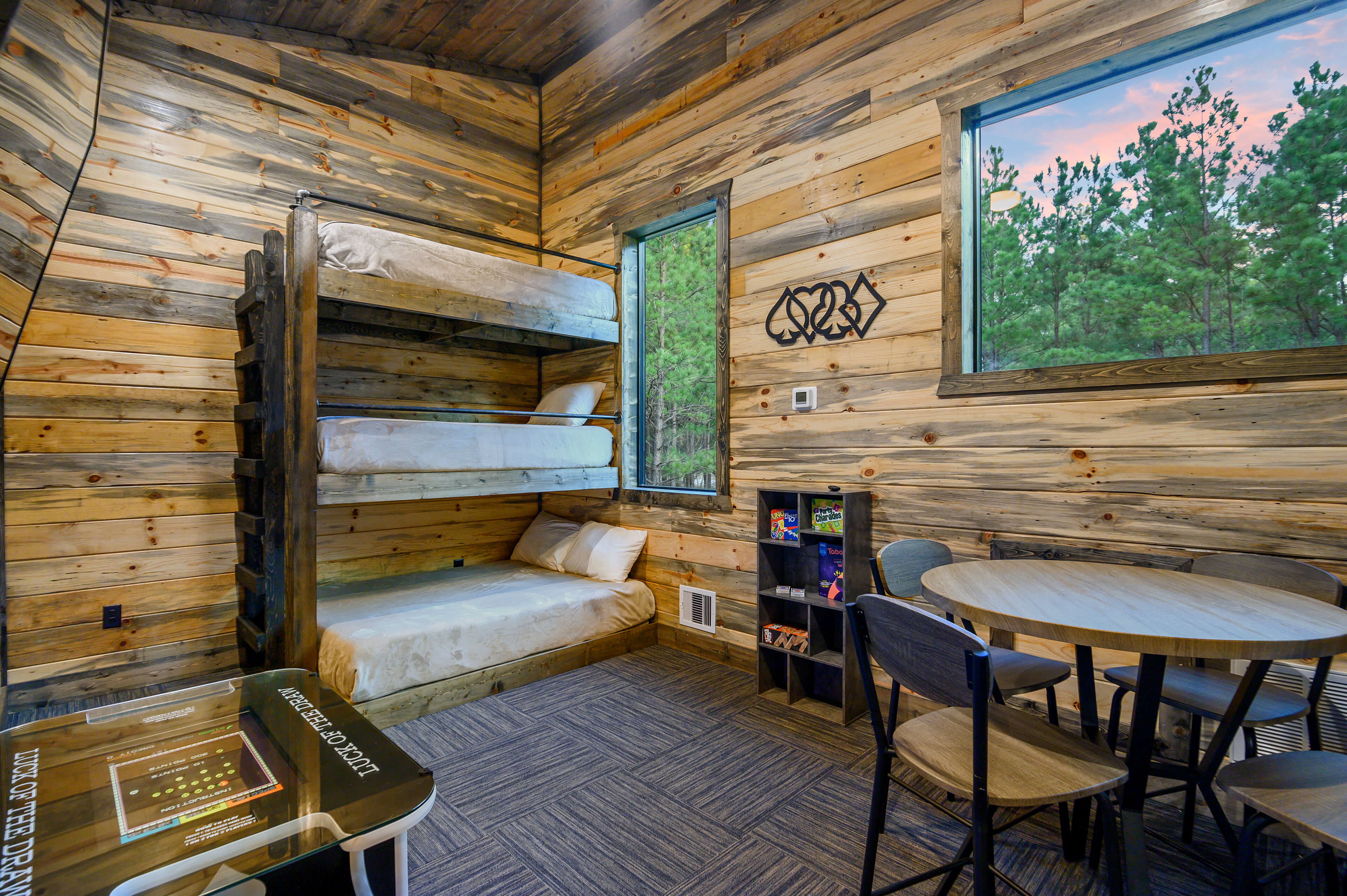 Charming loft bedroom with wooden ceilings, cozy beds, and rustic decor.
