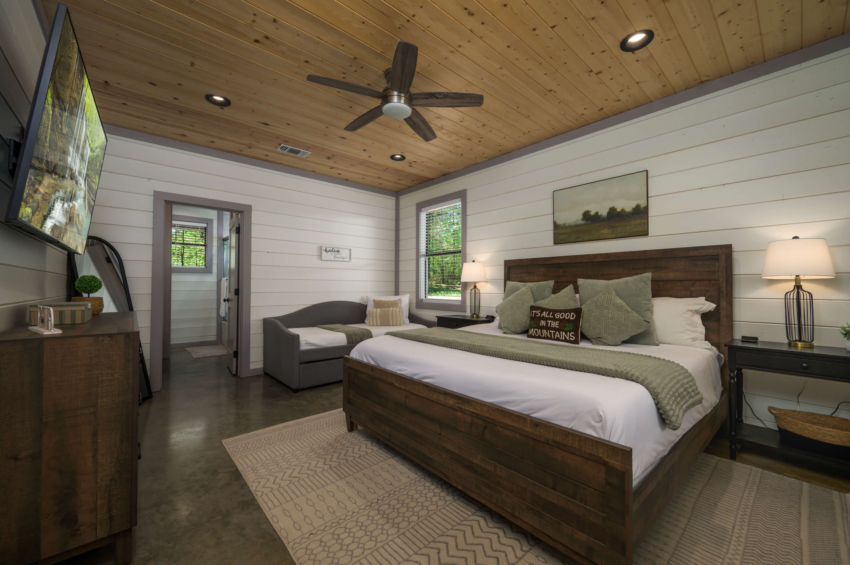 Rustic bedroom with wood accents, modern decor, and ample natural light.