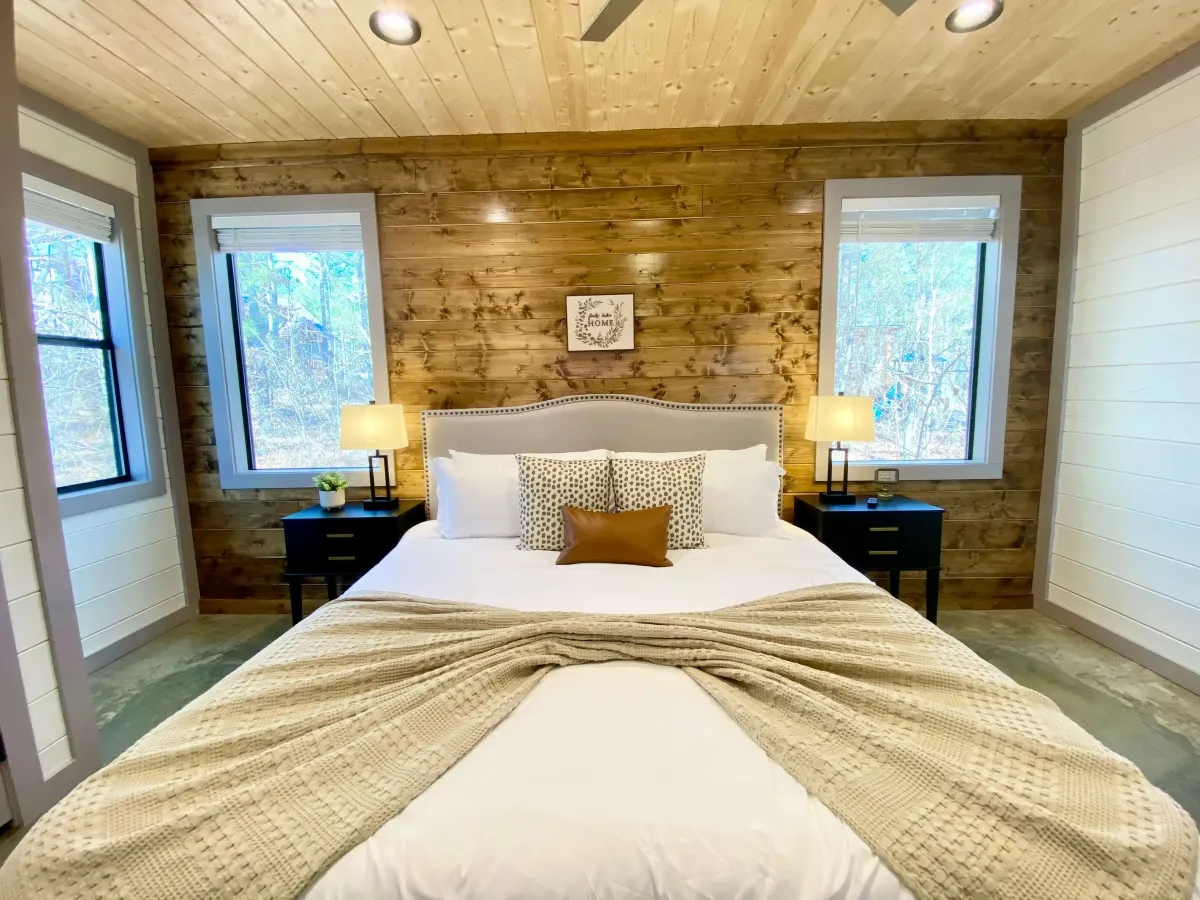 Rustic bedroom with wood accents, modern decor, and ample natural light.