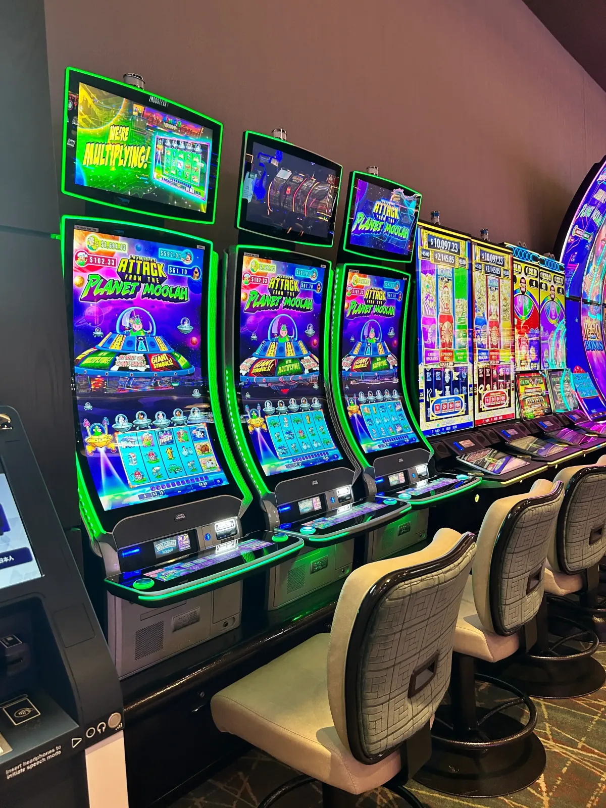 Colorful slot machines in a casino with comfortable seating arrangement.