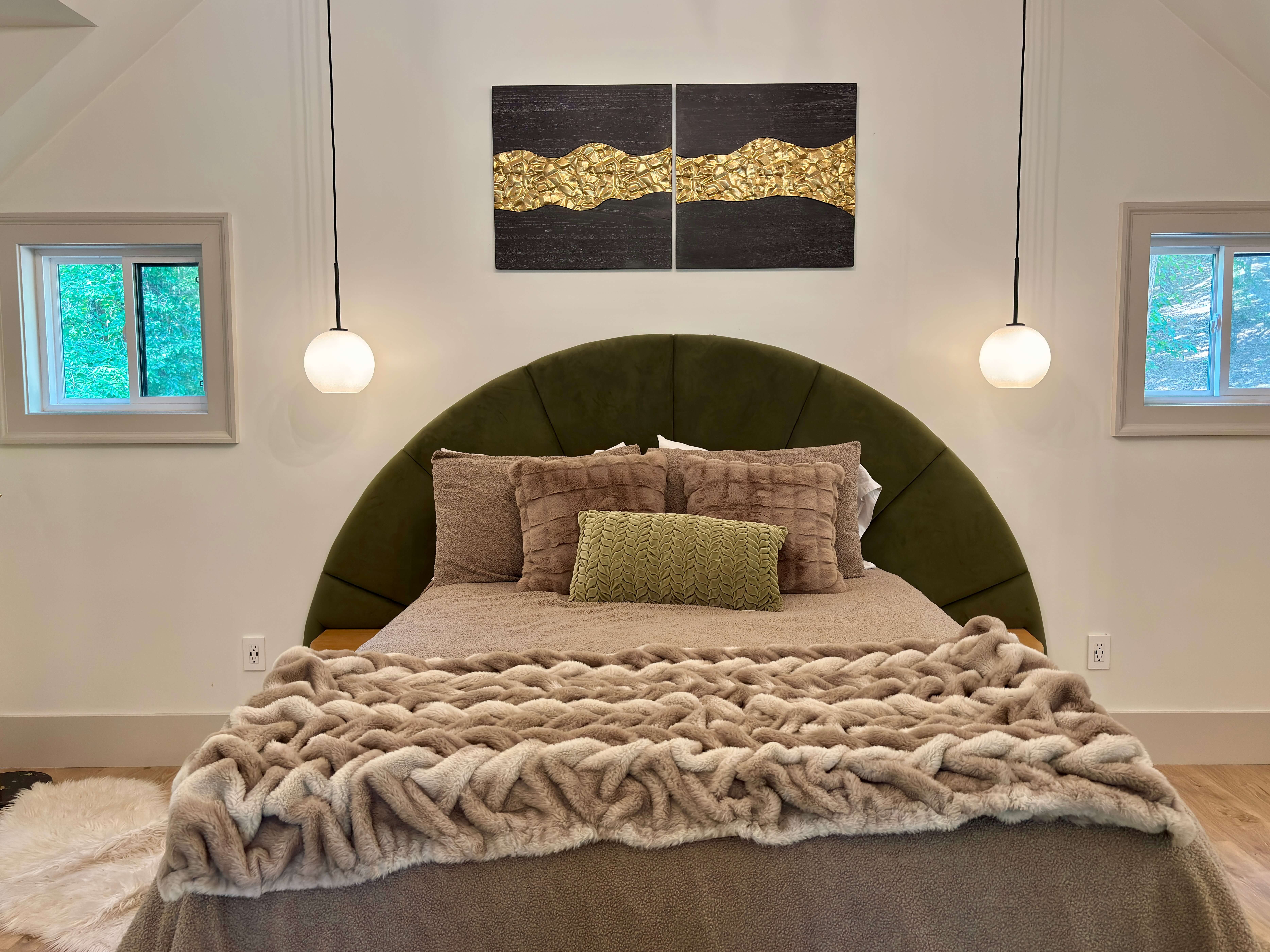 Inviting bedroom with large windows, plush bedding, and peaceful forest views.