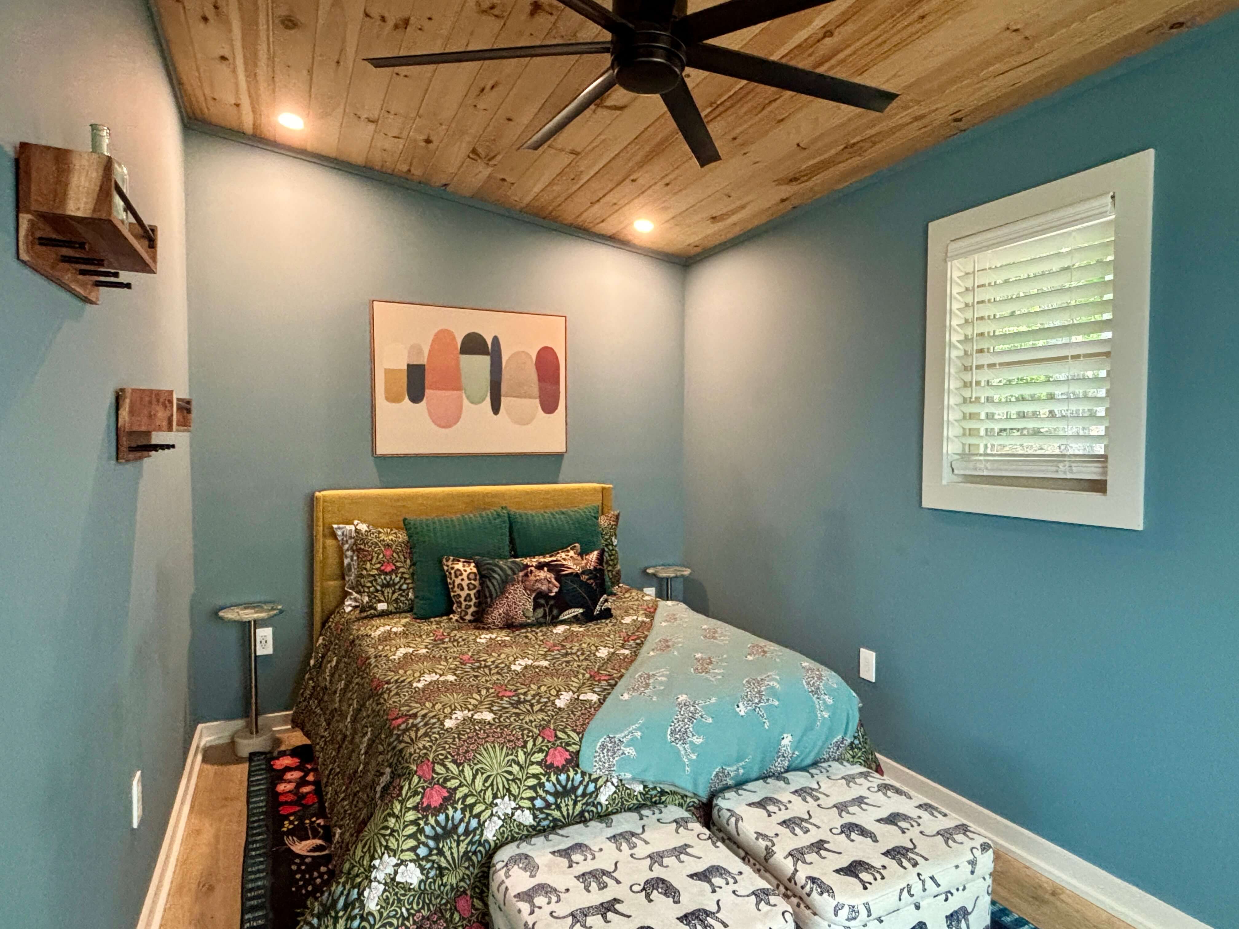 Charming loft bedroom with wooden ceilings, cozy beds, and rustic decor.