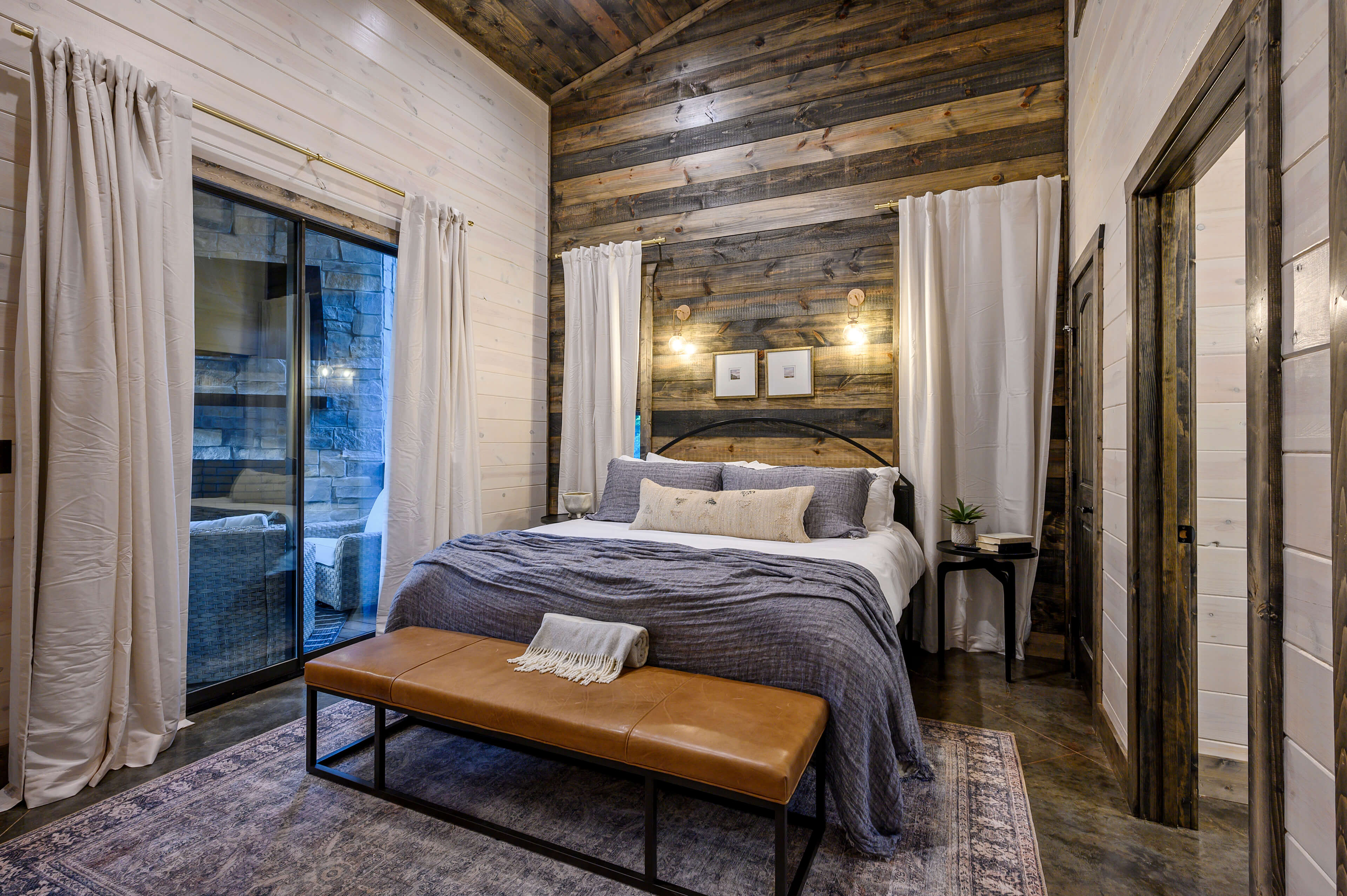 Modern cabin bedroom with white bunk beds, wood walls, and cozy blue decor.