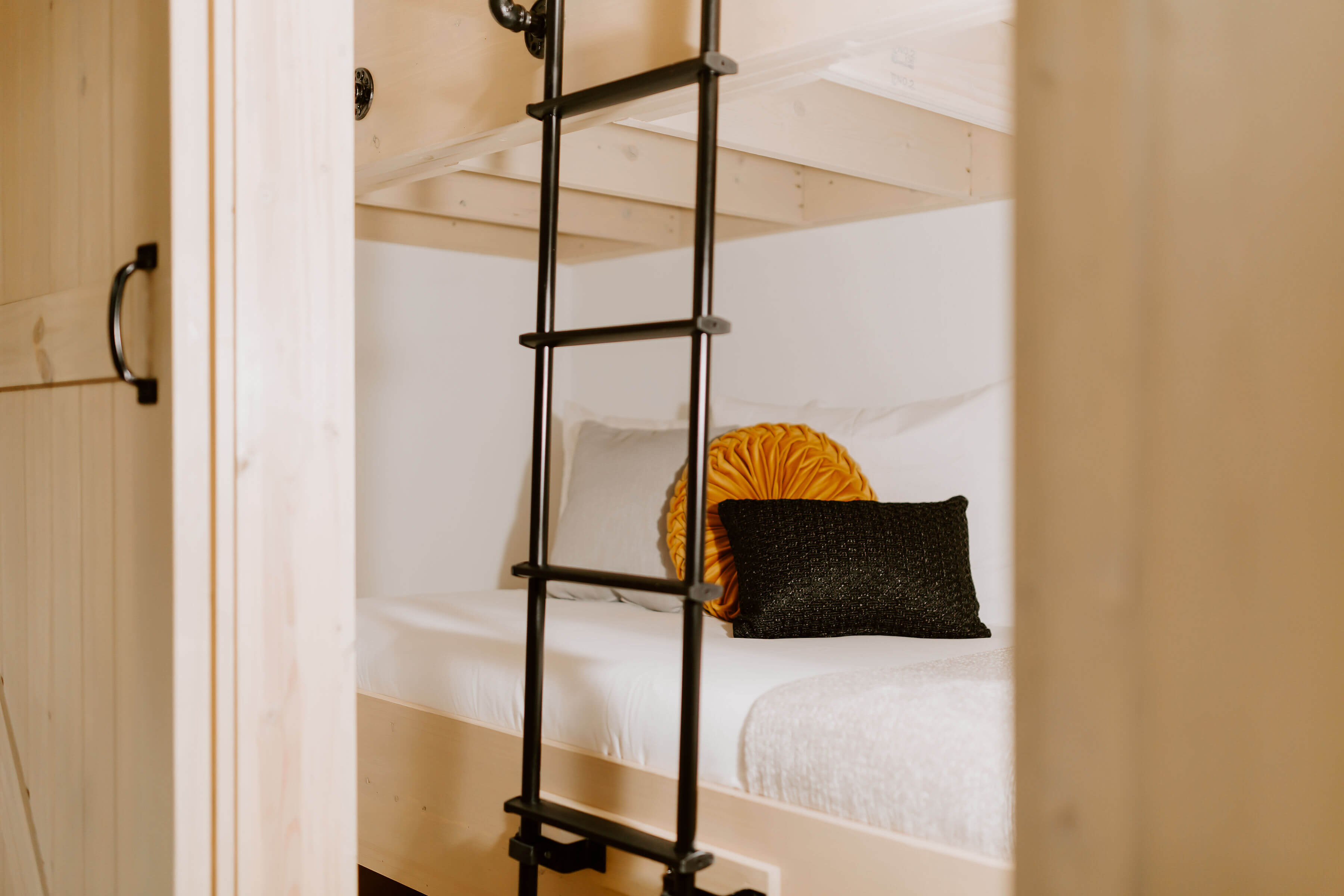 Warm bunk bedroom with wood walls, cozy lighting, and vibrant bedding.